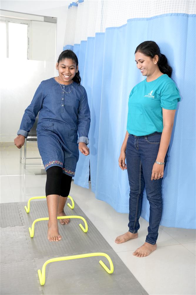 Patient stepping over agility hurdles during a PhysioShine sports injury rehabilitation session