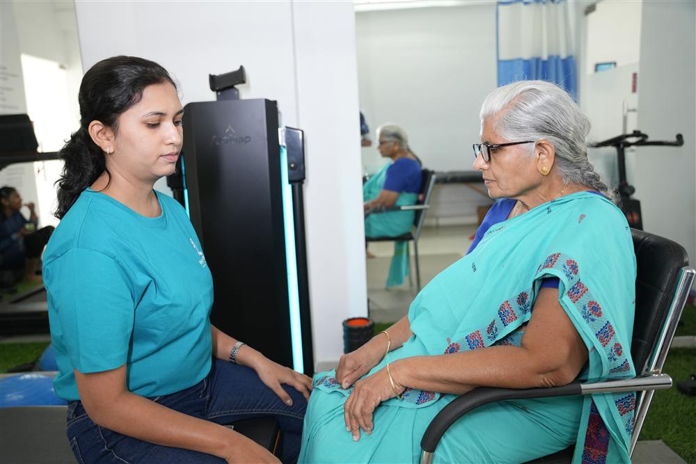 PhysioShine therapist consulting with an elderly patient during a geriatric mobility session