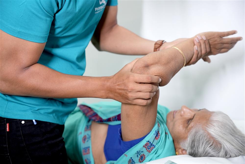 Hands-on shoulder mobilisation on the treatment table during orthopedic physiotherapy at PhysioShine